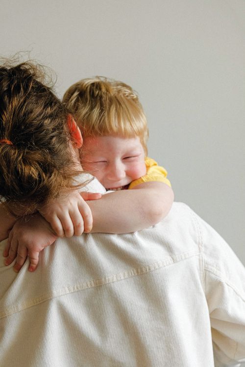 A young boy warmly hugging his mother